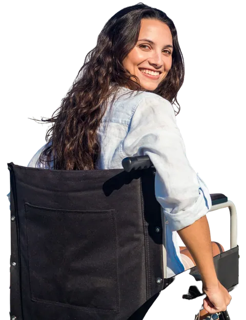 A young woman in a wheelchair looking back over her shoulder and smiling