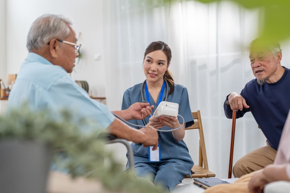 A nurse showing an older man something on a tablet