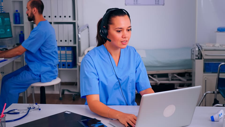 A nurse working at her desk with a laptop