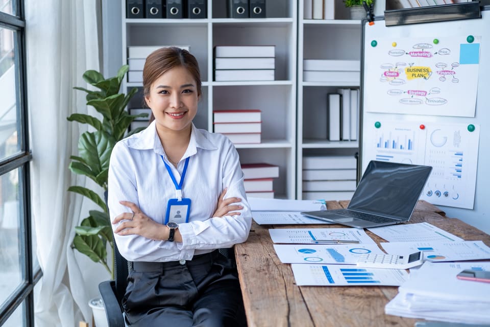 A smiling office manager standing at her desk