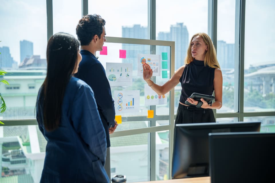 Colleagues planning at a glass wall of notes