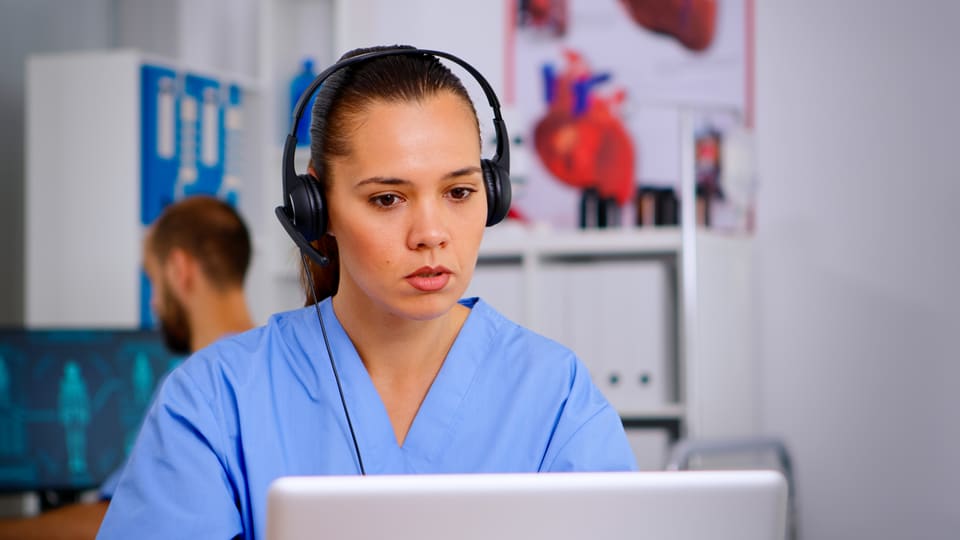 A coordinator on a headset at her desk