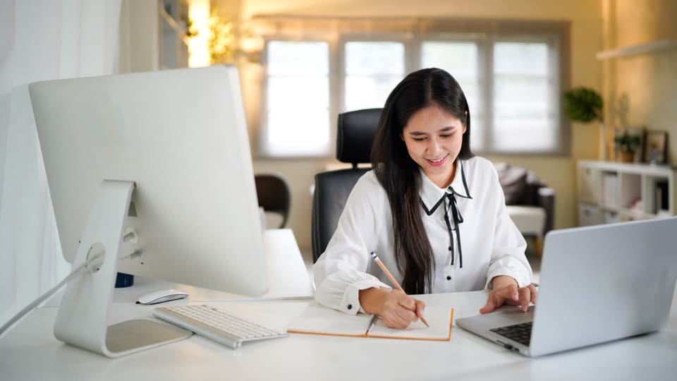 A smiling coordinator working at her desk