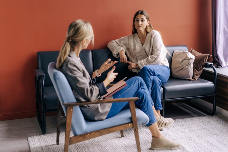 Two women talking on a sofa