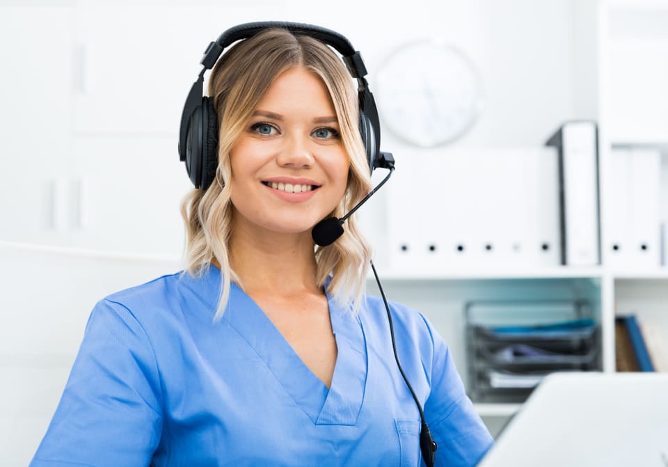 A smiling care worker on a headset