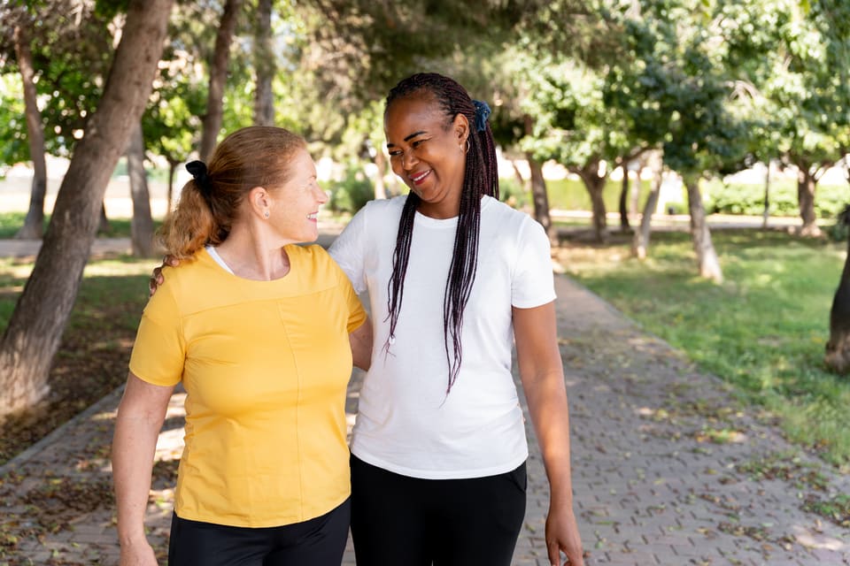 Two women walking and talking in a park