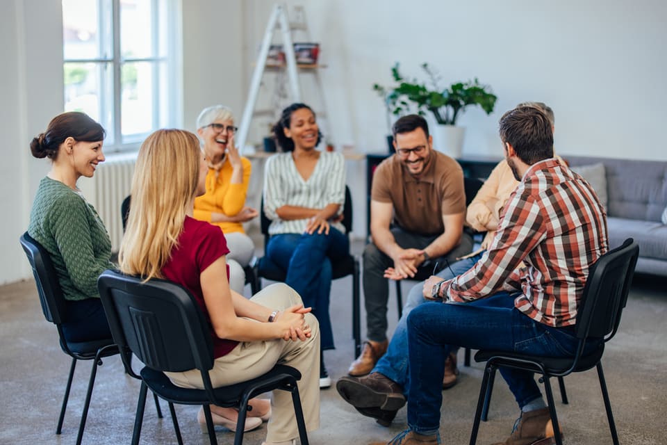A peer support group sitting in a circle, talking