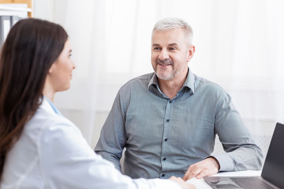 A coordinator talking with a man across a desk